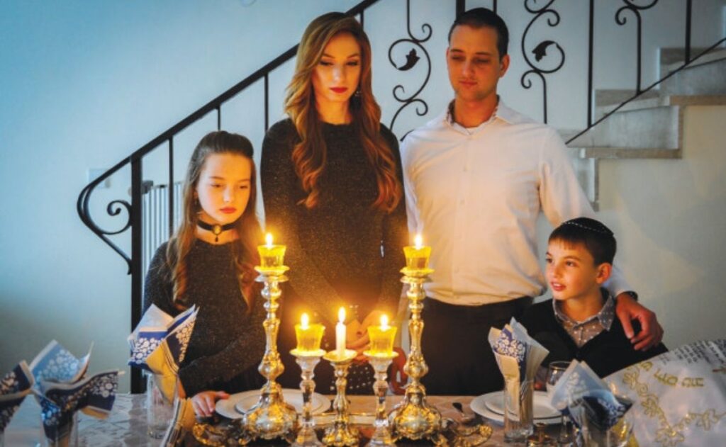 Familia judía se reúne después de encender velas de Shabat.