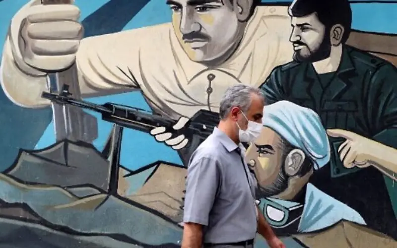 Los iraníes pasan por delante de un mural que representa la Revolución iraní en la Plaza de Palestina en la capital, Teherán, el 31 de julio de 2022. 