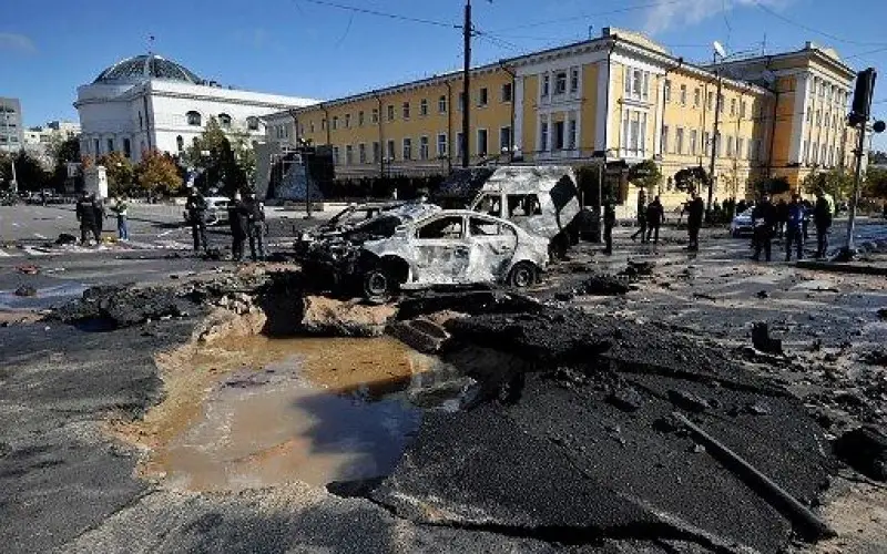 Expertos policiales examinan automóviles destruidos en el centro de la capital ucraniana de Kiev después de varios ataques rusos.