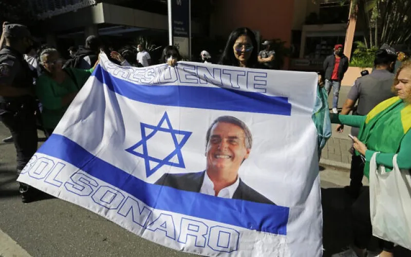 Partidarios del presidente brasileño Jair Bolsonaro sostienen una bandera israelí con la imagen de Bolsonaro, mientras esperan frente a un hospital donde Bolsonaro se recupera de una obstrucción intestinal en Sao Paulo, Brasil