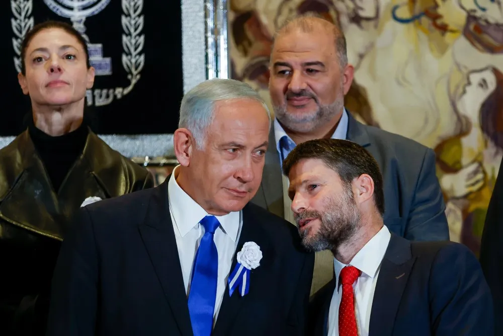 El líder del Likud, el diputado Benjamin Netanyahu, habla con el jefe del partido Sionista Religioso, el diputado Bezalel Smotrich, mientras los jefes del partido posan para una fotografía grupal durante la ceremonia de juramentación de la 25a Knesset, el 15 de noviembre de 2022.