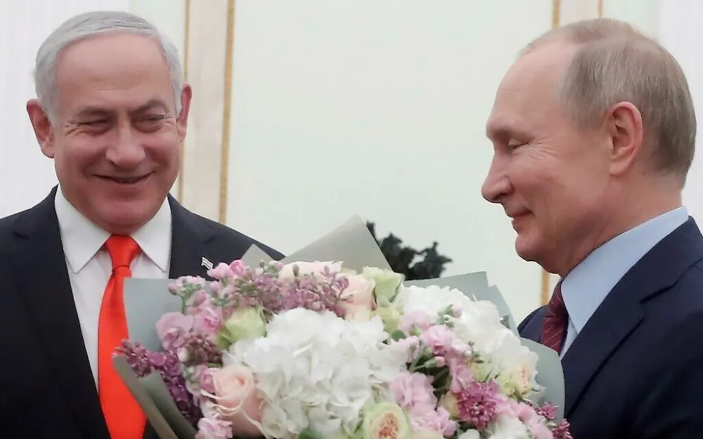El presidente ruso Vladimir Putin (derecha) con un ramo de flores y el primer ministro Benjamin Netanyahu en el Kremlin en Moscú.