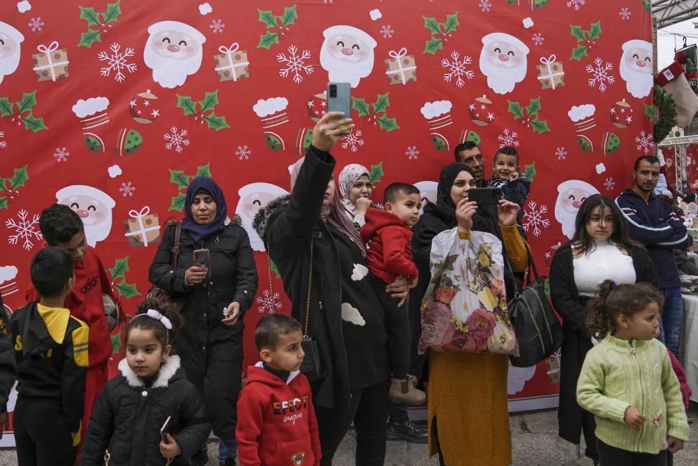 Palestinos visitan la Plaza del Pesebre decorada antes de Navidad, afuera de la Iglesia de la Natividad, en Belén, noviembre. 27, 2022.