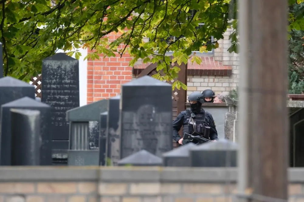 Policías son vistos detrás de las lápidas de un cementerio judío cerca del lugar de un tiroteo en Halle an der Saale, en el este de Alemania