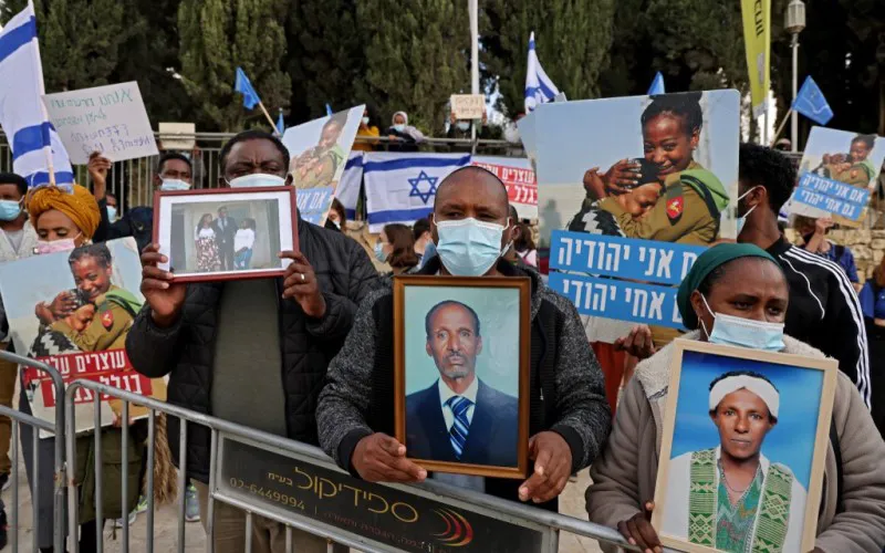 Miembros de la comunidad israelí etíope sostienen fotografías de sus familiares frente a la Oficina del Primer Ministro en Jerusalén.