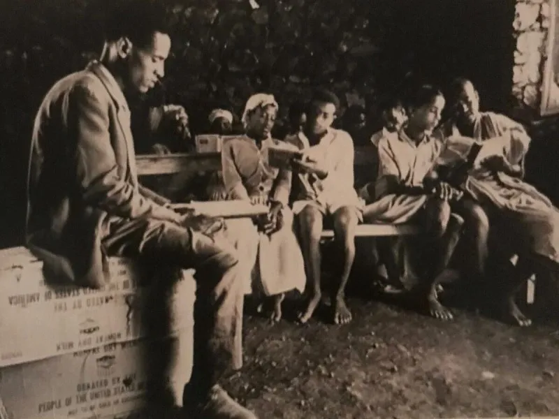 Rahamim Elazar, segundo por la derecha, de niño en Etiopía, donde tres estudiantes tuvieron que compartir un libro de trabajo en la escuela de su aldea.