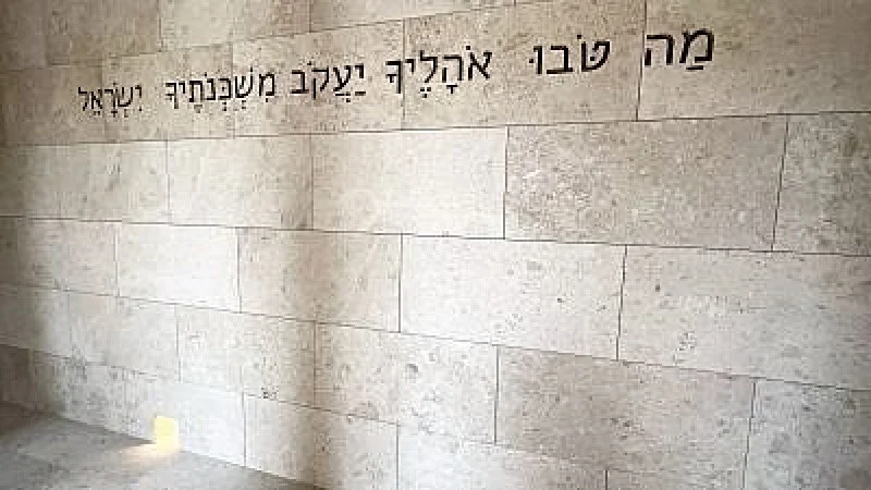 Una inscripción de Números 24:5 ("Cuán hermosas son tus tiendas, Jacob, tus moradas, Israel") en la Sinagoga Moisés Ben Maimon en el sitio de la Casa de la Familia Abrahámica en la isla Saadiyat, Emiratos Árabes Unidos.