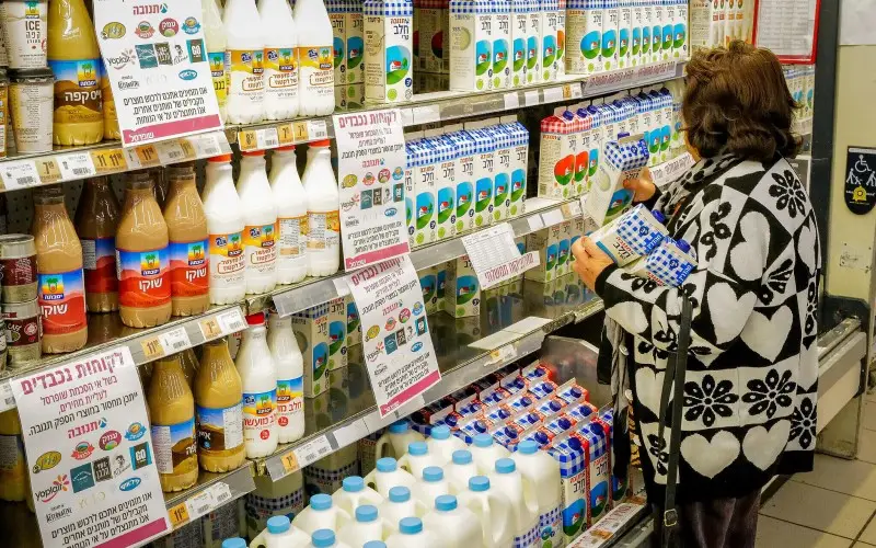 Personas compran productos lácteos en el supermercado Shufersal Deal en Katzrin.