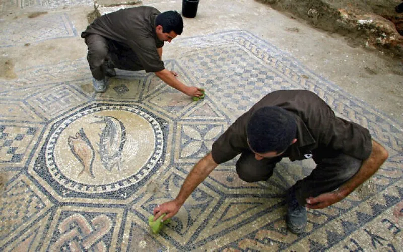 Los prisioneros trabajan en un piso decorado de casi 1.800 años de antigüedad de una sala de oración cristiana primitiva descubierta en la prisión de Meguido por arqueólogos israelíes.