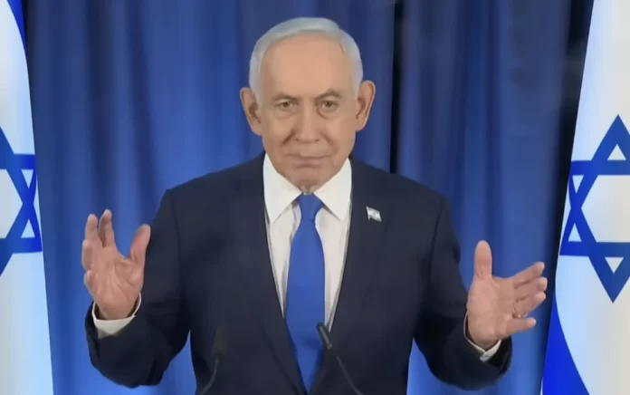 El primer ministro israelí Benjamin Netanyahu habla por videollamada durante su primera rueda de prensa desde el inicio de la guerra con Irán, flanqueado por dos banderas israelíes
